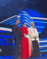a man and two women stand on a stage with a microphone
