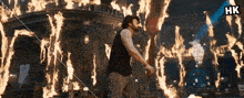 a man is standing in front of a room filled with fire .