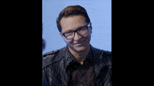 a man wearing glasses and a leather jacket is giving a thumbs up sign
