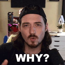 a man with long hair and a beard is asking why