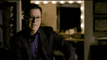 a man in a suit and glasses is making a face