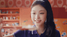 a young woman in a purple shirt is holding a piece of food in her hand and smiling .