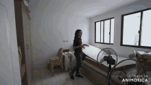 a woman is carrying a mattress in a room with the words made in animotica on the bottom right