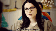 a woman wearing glasses is asking if someone is kidding her .