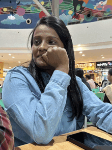 a woman sitting at a table in front of a domino 's sign