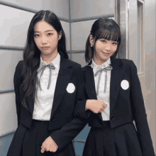 two girls in school uniforms pose for a picture together