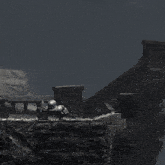 a black and white photo of a person holding a shield on a cliff