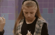 a young girl is holding a piece of paper and a pencil in her hand .