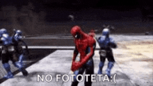 a spiderman is dancing in a video game while a group of soldiers are standing behind him .