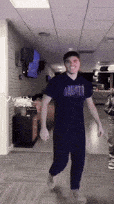 a man wearing a t-shirt that says almost walking down a hallway