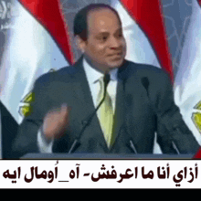 a man in a suit and tie is giving a speech in front of microphones