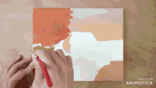 a person is painting on a canvas that says made in animotica on the bottom