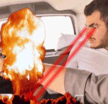a man is sitting in a car with a fireball coming out of his mouth