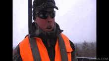 a man wearing sunglasses and an orange vest with a gifrun.com watermark