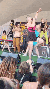 a woman singing into a microphone while a man plays a trumpet and a woman plays a saxophone