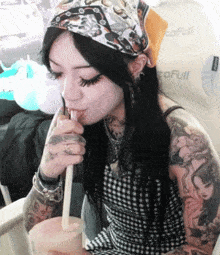 a woman is drinking through a straw in front of a cofull seat