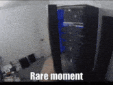 a person is holding a remote control in front of a blue computer tower that says rare moment