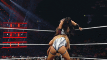a woman is wrestling in a ring with the word raw on the wall