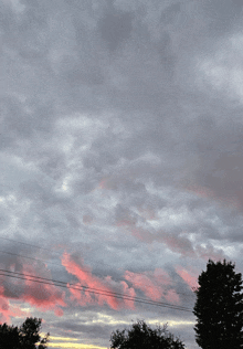 a cloudy sky with a pink cloud in the middle