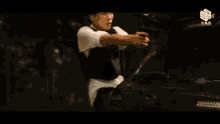 a man in a white shirt is laying on the floor with his arms up