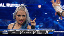 a female wrestler is pointing at the camera during a royal rumble