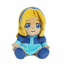 a stuffed doll with blonde hair and blue eyes sits on a white surface