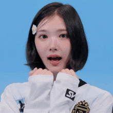 a girl with a flower in her hair is wearing a white shirt with the letter s on it