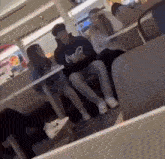 a group of young people are sitting at tables in a restaurant .