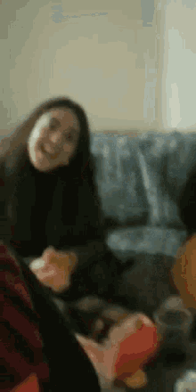 a group of people are sitting on a couch eating chips and drinking beer .