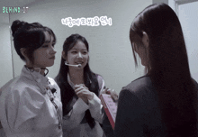 behind it is written on the bottom of a video of three girls
