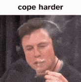 elon musk is smoking a cigarette while wearing headphones .