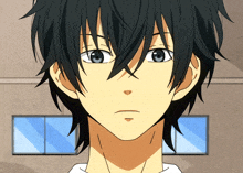 a close up of a boy 's face with black hair and blue eyes