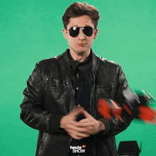a man wearing sunglasses and a leather jacket with the word heute show on the bottom