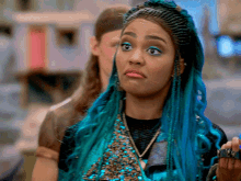 a woman with blue hair and braids is making a funny face