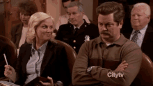 a man and a woman are sitting in a courtroom with a citytv logo on the bottom right