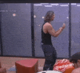 a man in a black tank top is dancing in front of a screen that says youtube
