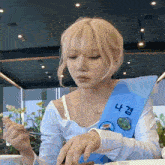 a woman wearing a blue sash with korean writing on it is eating food