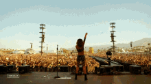 a woman stands on a stage in front of a crowd at a music festival with a caption that says coachella