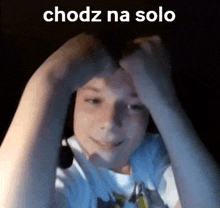 a person is making a heart shape with their hands on their forehead .