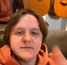 a man is sitting on a couch giving a thumbs up .