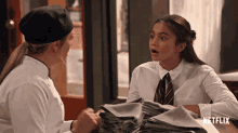 a woman in a chef 's hat talks to a girl in a school uniform