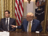marco rubio sits at a table with donald trump