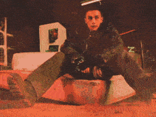 a painting of a man sitting on a box with the letter m in the corner