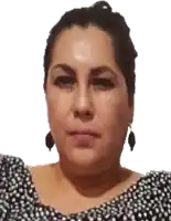 a woman wearing a black and white polka dot shirt and earrings looks at the camera