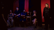 a group of people are sitting around a clock
