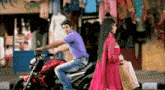 a man riding a motorcycle next to a woman in a red dress
