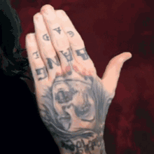 a close up of a person 's hand with a tattoo of a skull and the word bang on their fingers .