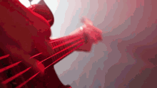 a close up of a person playing a guitar in red light