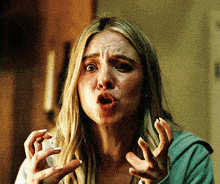 a woman is making a funny face with her hands in the air