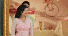 a man and a woman are standing next to each other in front of a mirror .